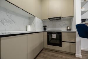a kitchen with white cabinets and an oven at GPM Home and Stay Apartments in Cluj-Napoca +9 photos