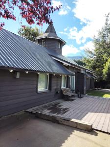 a building with a bench on a wooden deck at Casa Torre VLA in Villa La Angostura