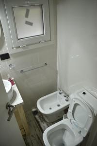 a white bathroom with a toilet and a sink at Casa Torre VLA in Villa La Angostura +19 photos