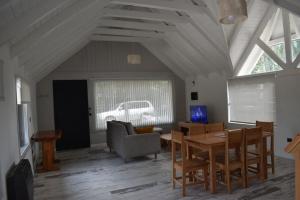 a living room with a table and a chair at Casa Torre VLA in Villa La Angostura