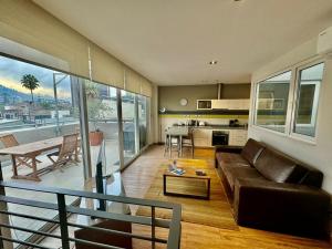 a living room with a leather couch and a kitchen at Lastarria Aparts in Santiago