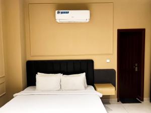 a bedroom with a bed with a air conditioner on the wall at Central City 2BHK by StayMehman in Rawalpindi