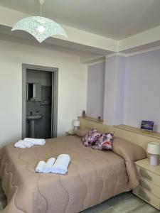 ein Schlafzimmer mit einem großen Bett, auf dem zwei Handtücher liegen in der Unterkunft Da Rita in Gerace