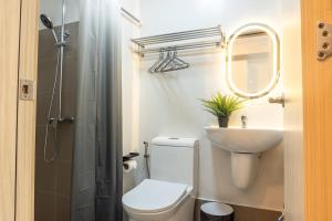 a bathroom with a toilet and a sink and a mirror at The Hmlet Manila, Near Poblacion Makati Nightlife in Manila