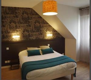 a bedroom with a bed with blue pillows at Relais du méne in Collinée