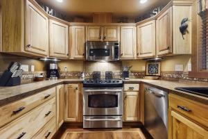 a kitchen with wooden cabinets and stainless steel appliances at Fireside Escape at Lake Cushman in Hoodsport