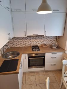 Una cocina con gabinetes blancos y un fregadero. en Rinktinės apartments, en Vilna