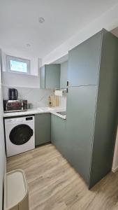 オルレアンにあるAppartement Van Goghのキッチン(緑のキャビネット、白い冷蔵庫付)