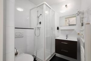 a bathroom with a shower and a toilet and a sink at Hotel Light in Rotterdam +31 photos