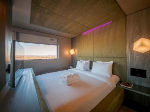 a bedroom with a white bed with a window at Bloc Hotel London Gatwick Airport in Horley +32 photos