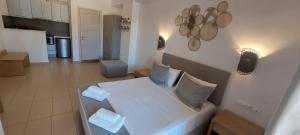 a living room with a bed and a kitchen at Selinopetra Rooms in Elafonisos