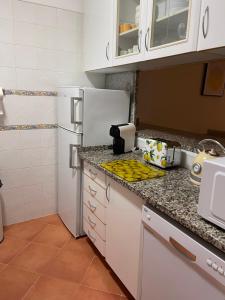 a kitchen with white cabinets and a white refrigerator at Condominio do Mar in Lagos