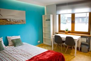 a bedroom with blue walls and a bed and a desk at Apartamenty Akacjowa przy Parku Szwedzkim in Szczawno-Zdrój