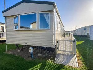 una pequeña casa en exhibición en un patio en Homely 8 Berth Caravan With Side Decking And Ramp Access In Kent, Ref 47018H, en Whitstable