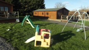 a yard with a playground with a slide at Spacious 3 bedroom cabin at Avonvale Holiday Lodge in Evesham