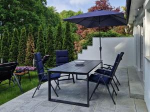 a table and chairs with an umbrella on a patio at Haus Wentowseeblick in Zehdenick