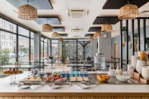 a breakfast buffet in a hotel with food on a counter at Appart hôtel Q7 Lodge Lyon 7 in Lyon