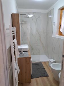 a bathroom with a sink and a toilet and a shower at Presolana Horizon in Castione della Presolana