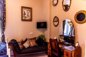 a living room with a couch and a mirror at Mulberry House in Llandudno