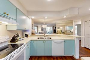 Una cocina con gabinetes azules y un fregadero. en Colonnade Club 147, en Hilton Head Island