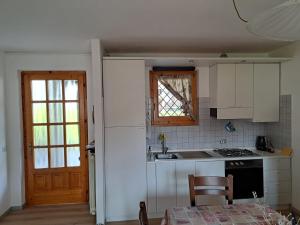 a kitchen with white cabinets and a stove top oven at Presolana Horizon in Castione della Presolana +13 photos