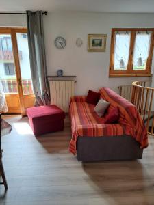 a bedroom with a bed and a couch and windows at Presolana Horizon in Castione della Presolana