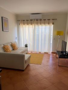 a living room with a white couch and a window at Condominio do Mar in Lagos