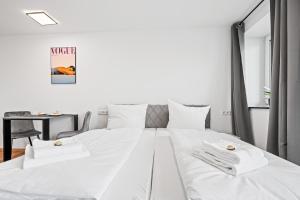a bedroom with a bed with white sheets and a table at Stilvolles Apartment Bodensee A2 in Ravensburg