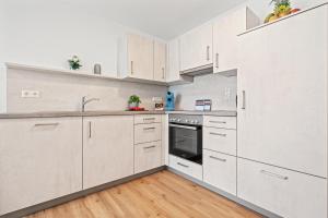 a kitchen with white cabinets and a sink at Stilvolles Apartment Bodensee A2 in Ravensburg