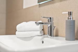 a bathroom sink with a faucet and some towels at Stilvolles Apartment Bodensee A2 in Ravensburg