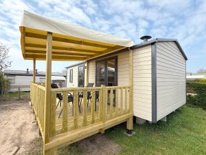 una casetta con portico e tenda da sole di MobilHome de la Coccinelle a Gujan-Mestras