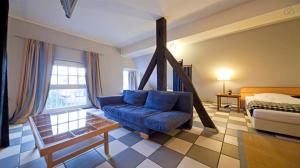 a living room with a blue couch and a bed at amazing historical appartment in Sendenhorst