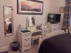 a bedroom with a desk with a tv and a mirror at Eastdale Bed and Breakfast in North Ferriby