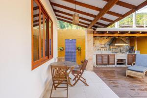 un patio con tavolo e sedie e una cucina di Casa Juquehy a São Sebastião