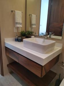 a bathroom with a white sink and a mirror at Central park lagunas in Tulum