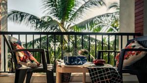 a table with two chairs and two cups on a balcony at Villa Vera - 2BHK Apartment in Baga