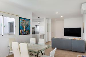a living room with a glass table and a television at Garden Terrace House - La Isleta in Guanarteme