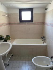 a bathroom with a tub and a toilet and a sink at Pinho Azul - Beach House in Apúlia +13 photos