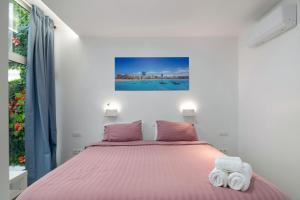 a bedroom with a bed with pink sheets and towels at Garden Terrace House - La Isleta in Guanarteme