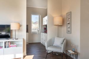 a living room with a chair and a television at Rodehuus Wohnung 4 in Borkum