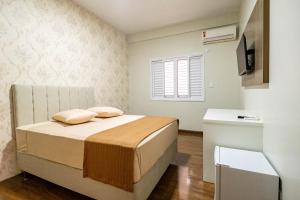 a small bedroom with a bed and a window at Arca's Express Hotel in Toledo