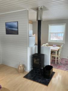 a wood stove in a room with a table at Røssøyhytta in Steigen +40 photos