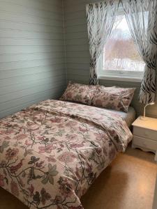 a bedroom with a bed and a window at Røssøyhytta in Steigen