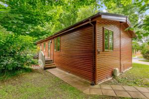 a wooden cabin with a staircase in a yard at Duet Lodge in Kingham