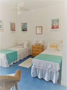 una stanza con due letti e una sedia di Villetta sul Mare incluso Accesso Stabilimento a San Felice Circeo