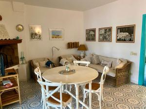 un soggiorno con un tavolo e un divano di Villetta sul Mare incluso Accesso Stabilimento a San Felice Circeo Altre 22 foto