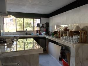 a kitchen with a sink and a counter with glasses at New house in the forest in Valle de Bravo +36 photos