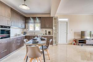 キオスにあるSpiladia Luxury Apartmentの木製のキャビネットとテーブルと椅子を備えたキッチン