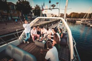 un grupo de personas sentadas alrededor de una mesa en un barco en Yacht EVASION La Rochelle - Bateau insolite, en La Rochelle