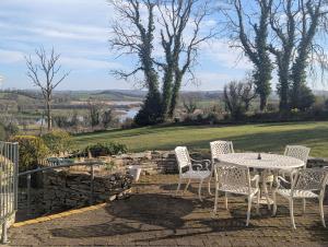 a patio with a table and chairs and a stone wall at Willowbank House and Lodges in Enniskillen +105 photos